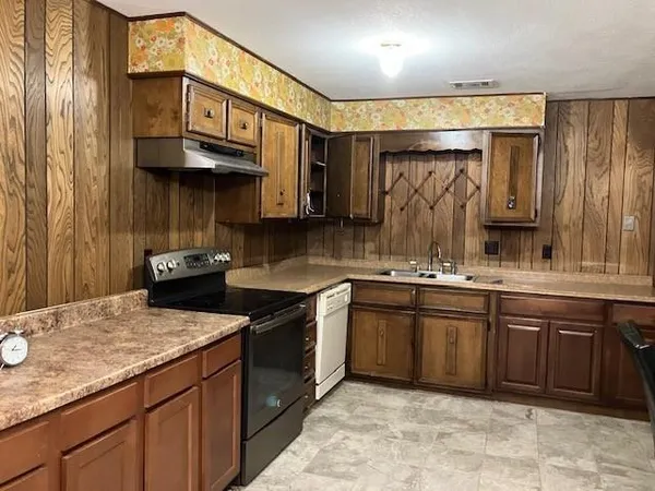 a kitchen with stainless steel appliances granite countertop a sink stove and cabinets