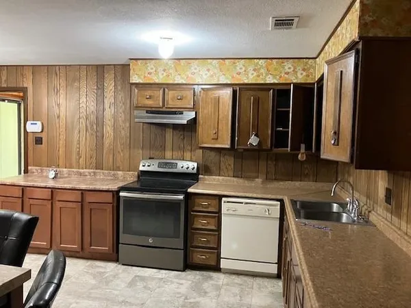 a kitchen with stainless steel appliances granite countertop a stove and a sink