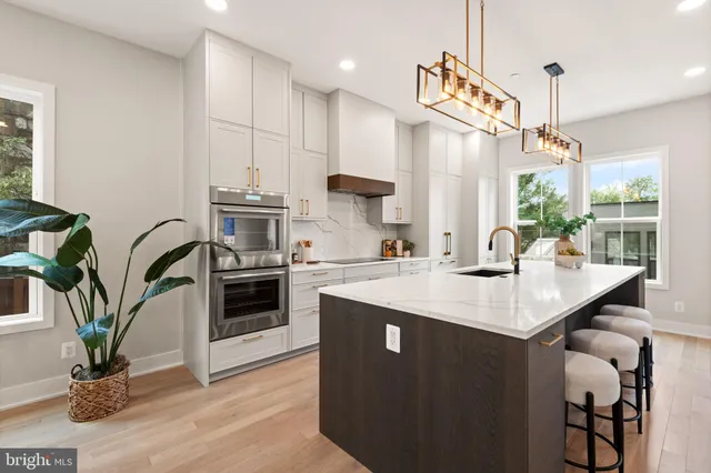a kitchen with stainless steel appliances kitchen island granite countertop a table and chairs in it