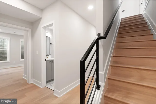 a view of an empty room with wooden floor and windows