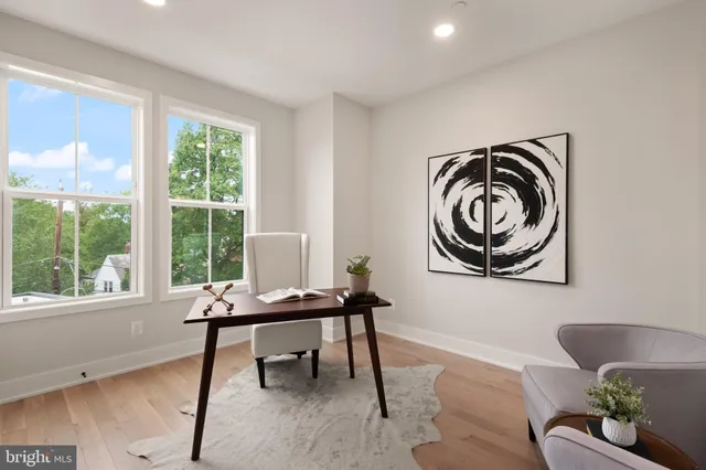 a bedroom with bed couch and large window