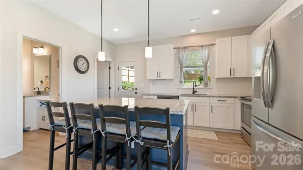 a kitchen with granite countertop a table chairs a sink stainless steel appliances and cabinets