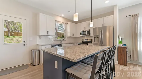 a kitchen with stainless steel appliances granite countertop a sink a stove a refrigerator and island