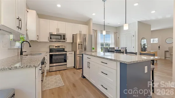 a kitchen with stainless steel appliances granite countertop a sink a stove and a refrigerator