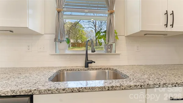 a kitchen with granite countertop a sink and a window