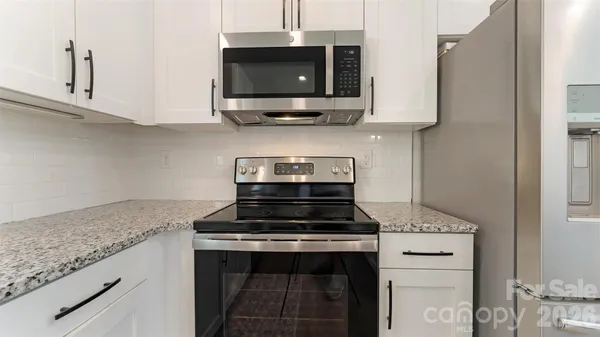 a kitchen with stainless steel appliances granite countertop a stove and a microwave