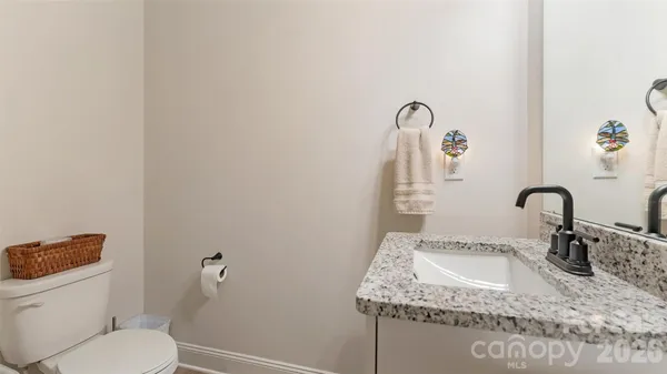 a bathroom with a granite countertop sink and a toilet