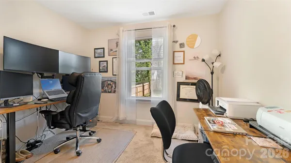 a view of a workspace with furniture and a window