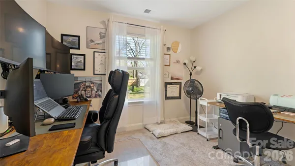 a view of a workspace with furniture and a window