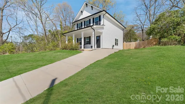 a front view of a house with a yard and trees