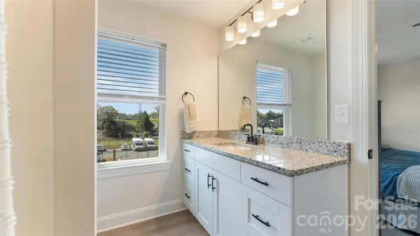 a bathroom with a granite countertop sink and a mirror