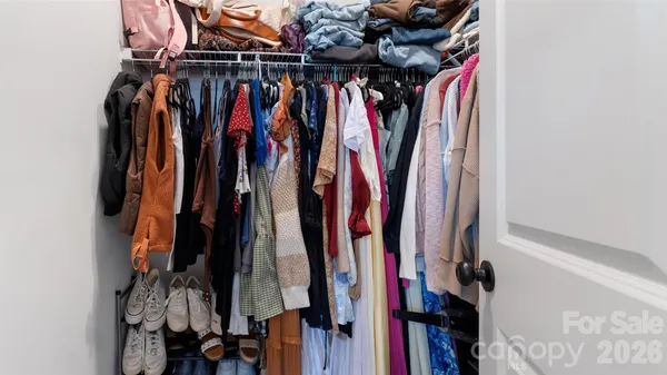 a view of walk in closet with clothes