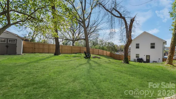 a view of a house with backyard and a tree
