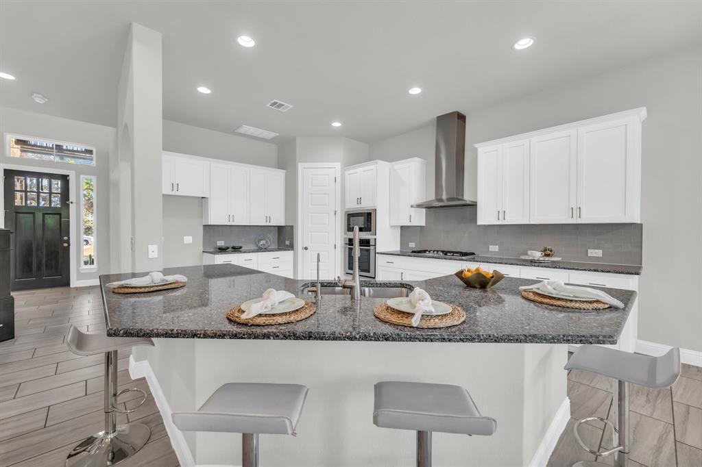110 Magona Trail Georgetown, TX 78628 - Photo 15 of 38 A contemporary kitchen features a spacious island with granite counters, perfect for casual dining and entertaining.