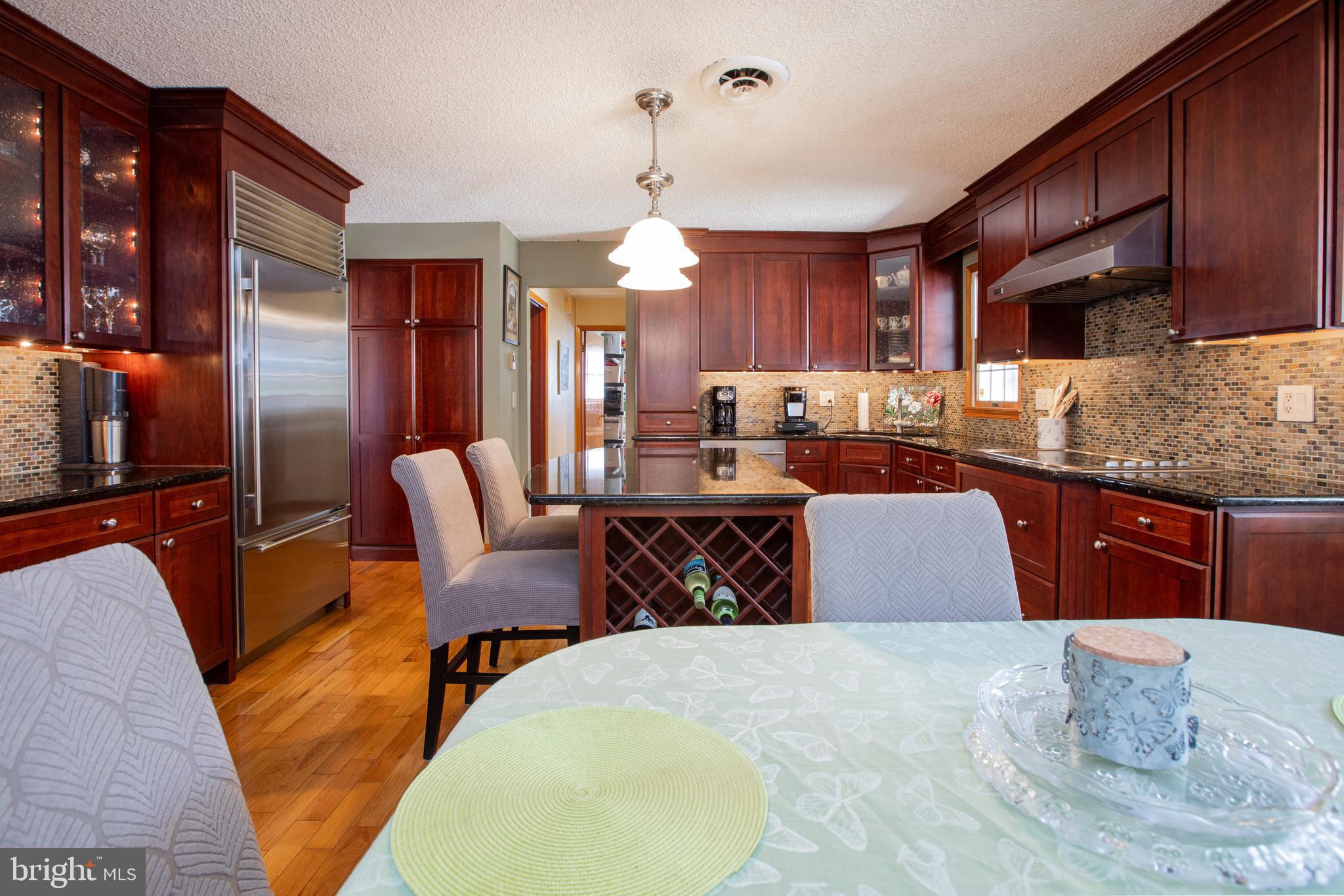 12 Millstream Road Cream Ridge, NJ 08514 - Photo 23 of 76 a kitchen with stainless steel appliances kitchen island granite countertop a table chairs in it and a wooden floors