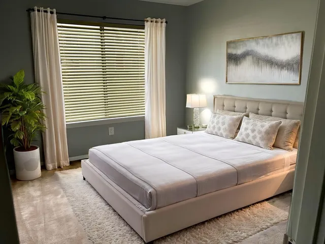 a bedroom with a large bed and a potted plant