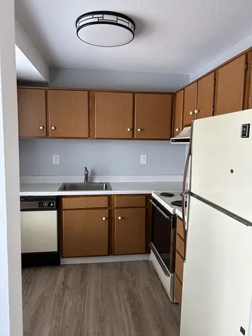 a kitchen with a refrigerator sink and cabinets