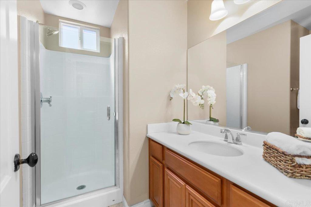 838 Luminara Way San Marcos, CA 92078 - Photo 31 of 54 a bathroom with a granite countertop sink a mirror and shower