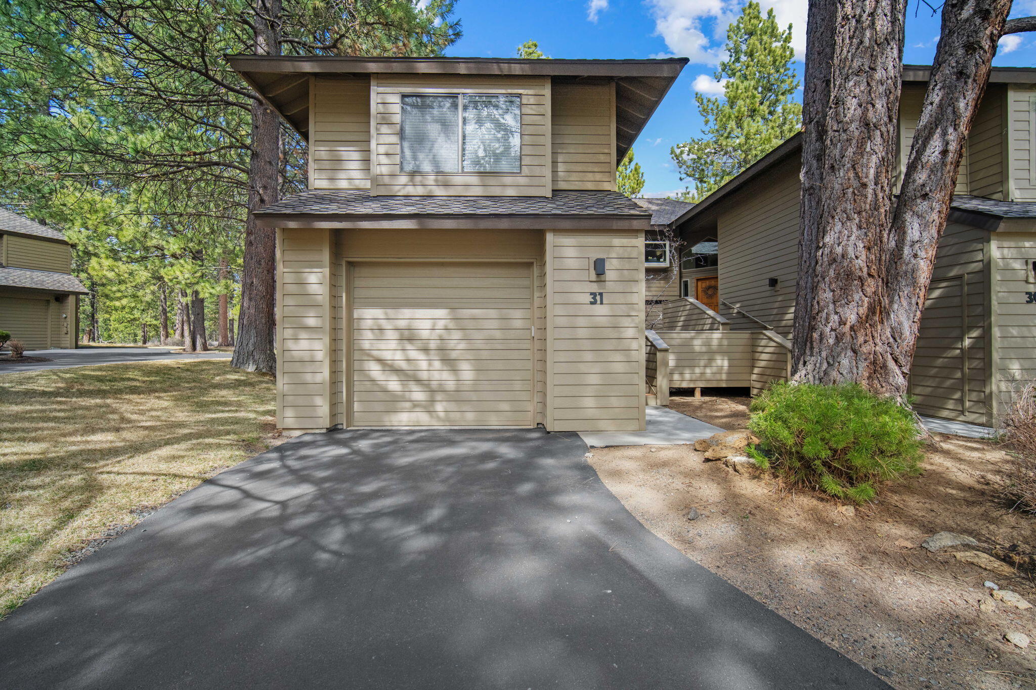 17682 Bittern Lane, Unit 31 Sunriver, OR 97707 - Photo 2 of 44 a view of a house with a garage and large tree