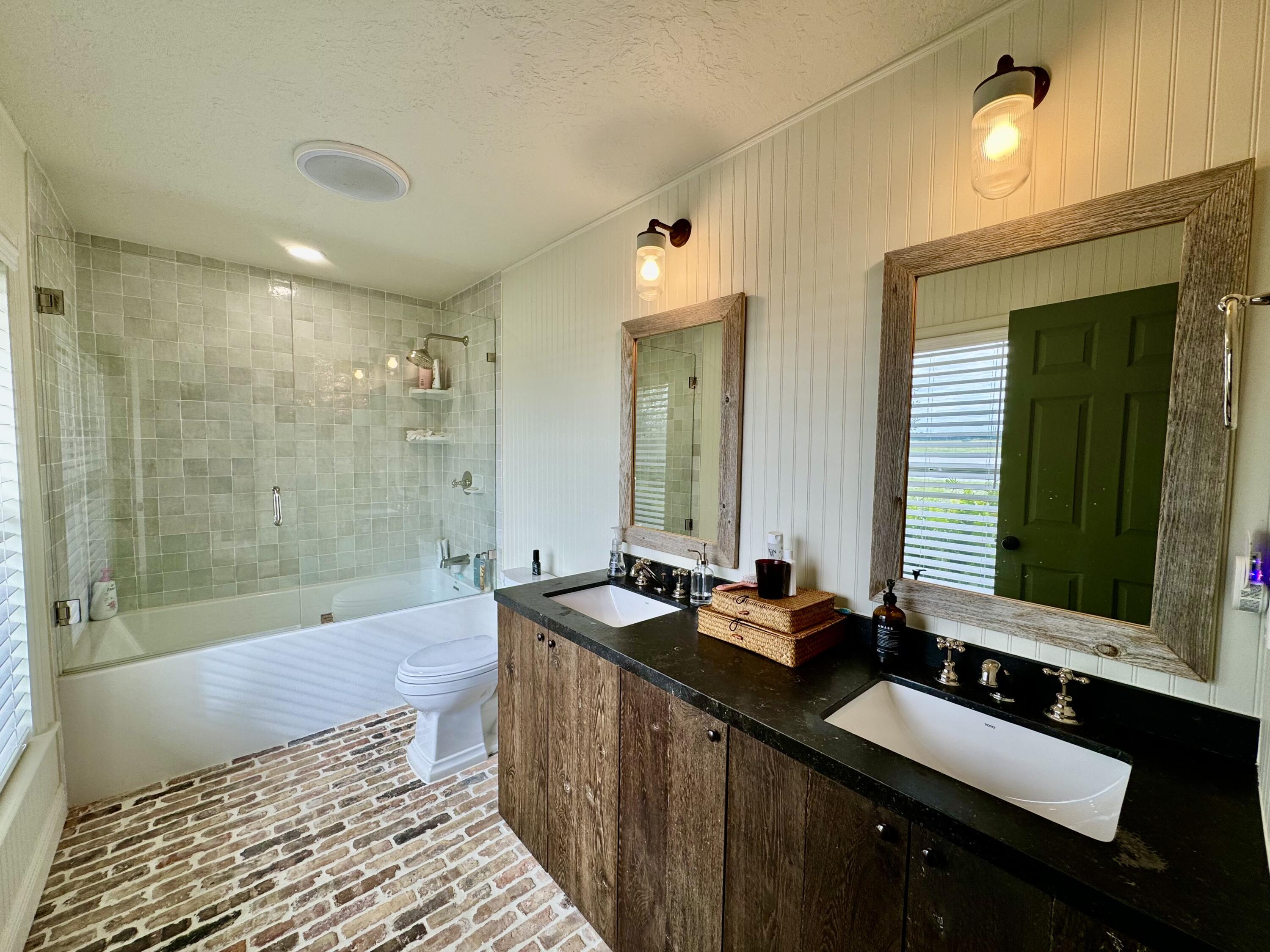 14151 Center Street Okeechobee, FL 34974 - Photo 8 of 16 a bathroom with a double vanity sink large mirror and a bathtub