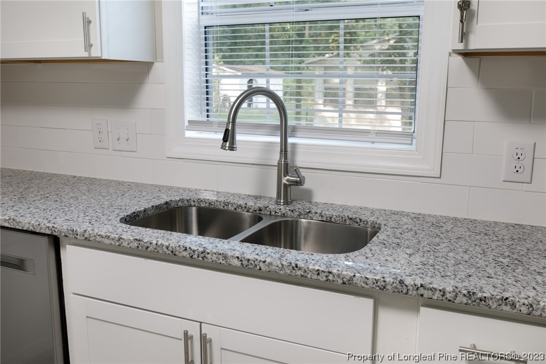 5348 Goldsboro Road Wade, NC 28395 - Photo 21 of 25 a kitchen with granite countertop a sink and wooden cabinets
