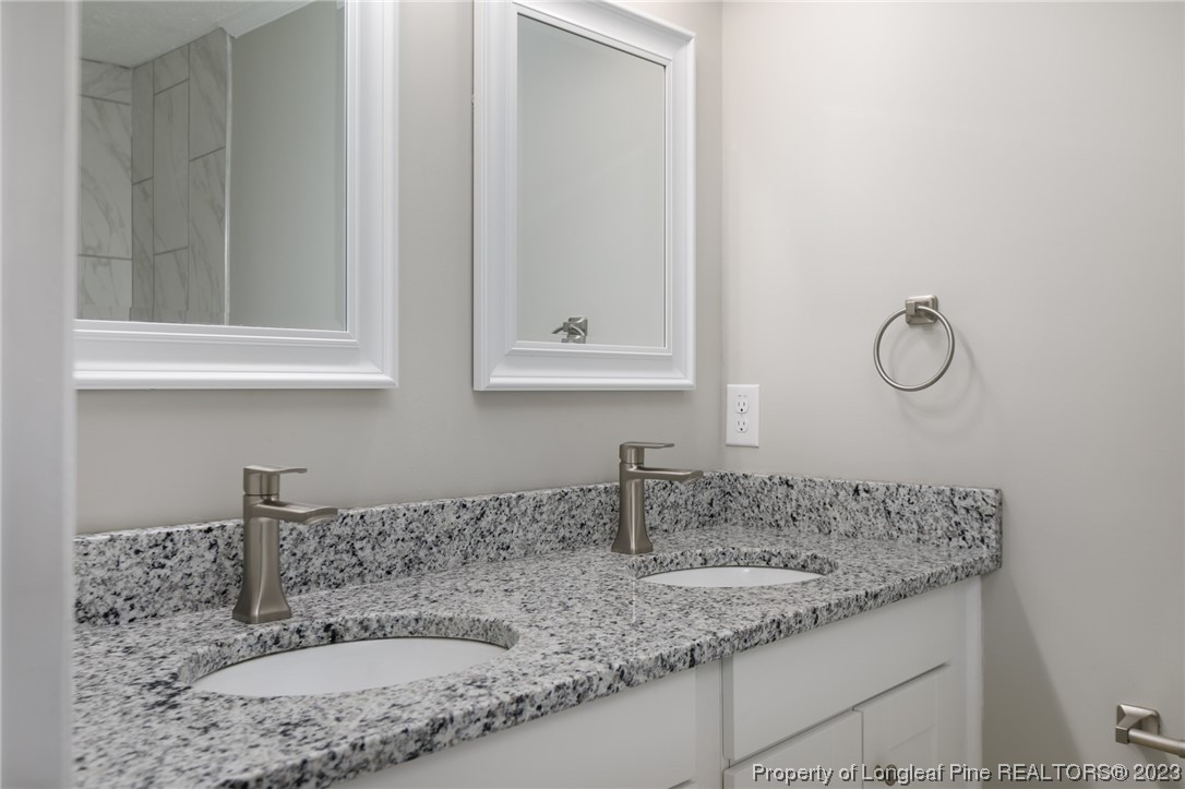 5348 Goldsboro Road Wade, NC 28395 - Photo 10 of 25 a bathroom with a granite countertop sink and a mirror