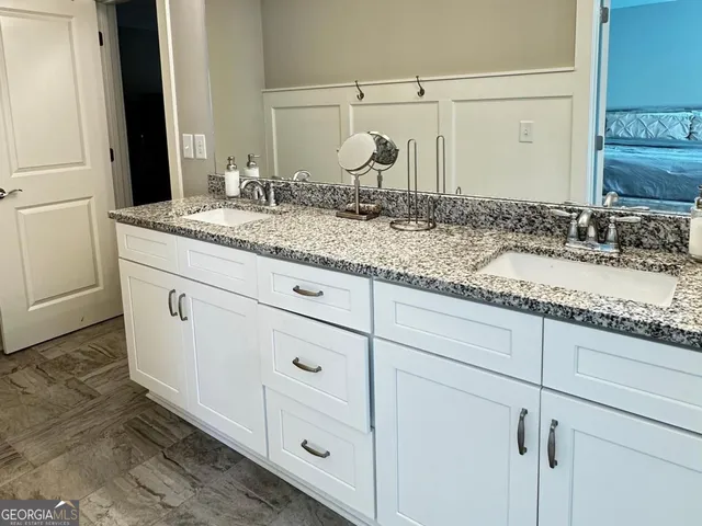 a bathroom with a granite countertop sink and a mirror
