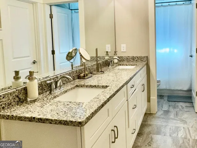 a bathroom with sink granite and a mirror