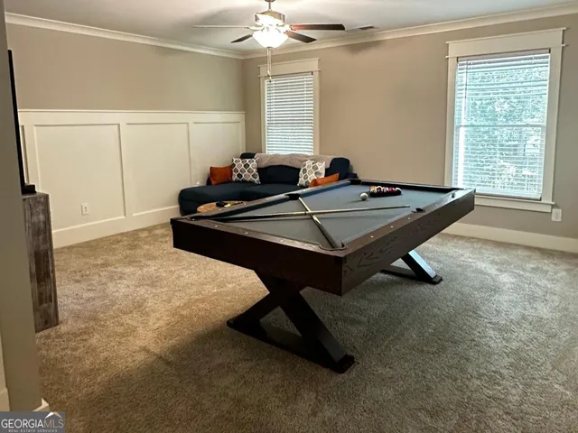 a room with pool table and windows