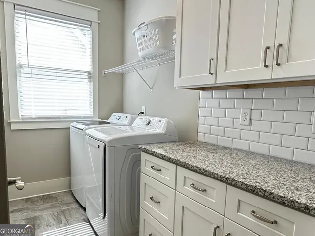 a utility room with granite countertop cabinets