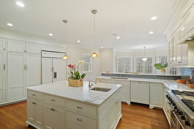 a kitchen with a sink a counter space appliances and cabinets
