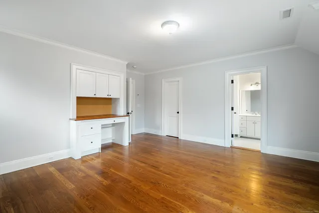 a view of empty room with wooden floor and cabinet