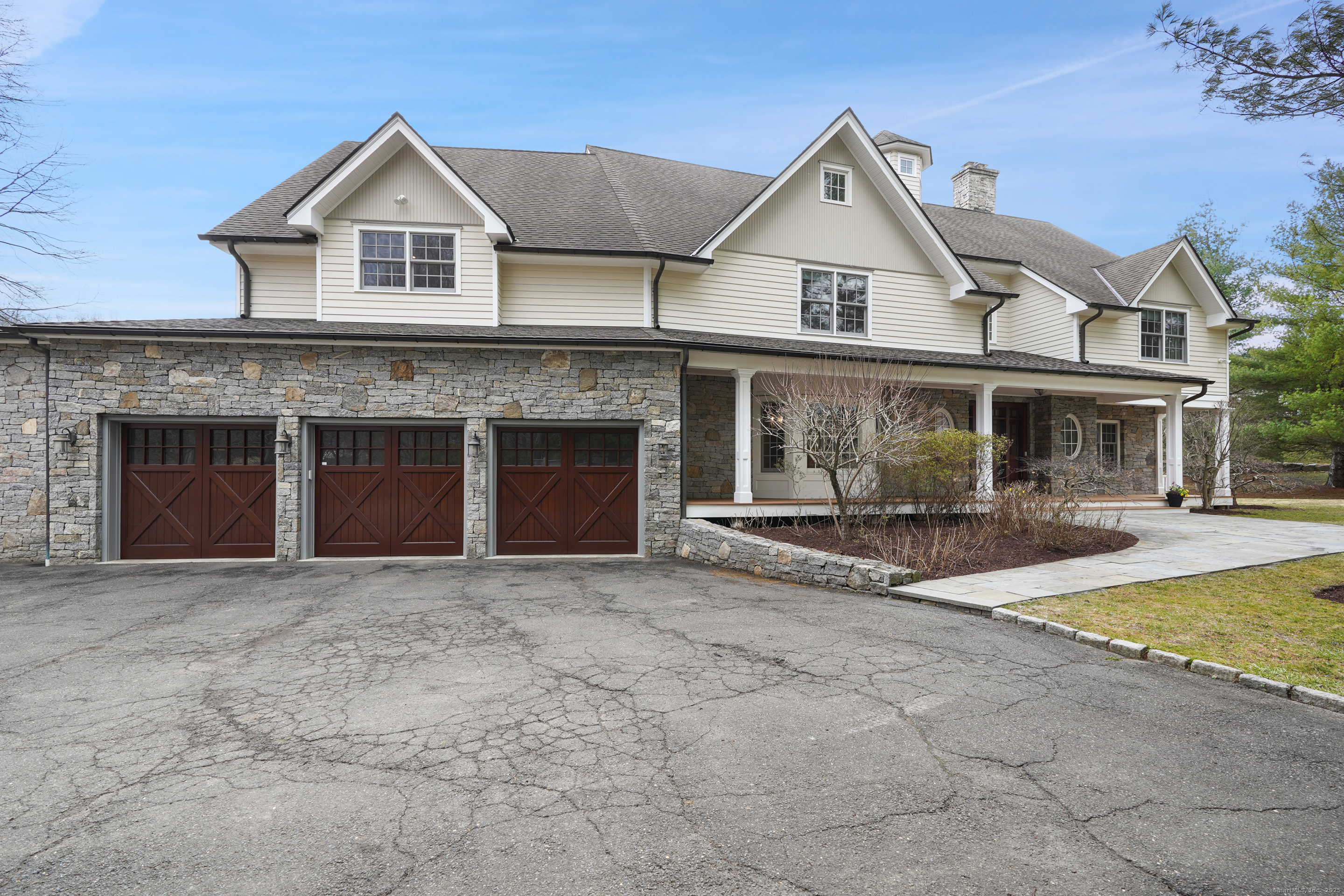 33 Middlebrook Farm Road Wilton, CT 06897 - Photo 3 of 40 a front view of a house with a yard and garage