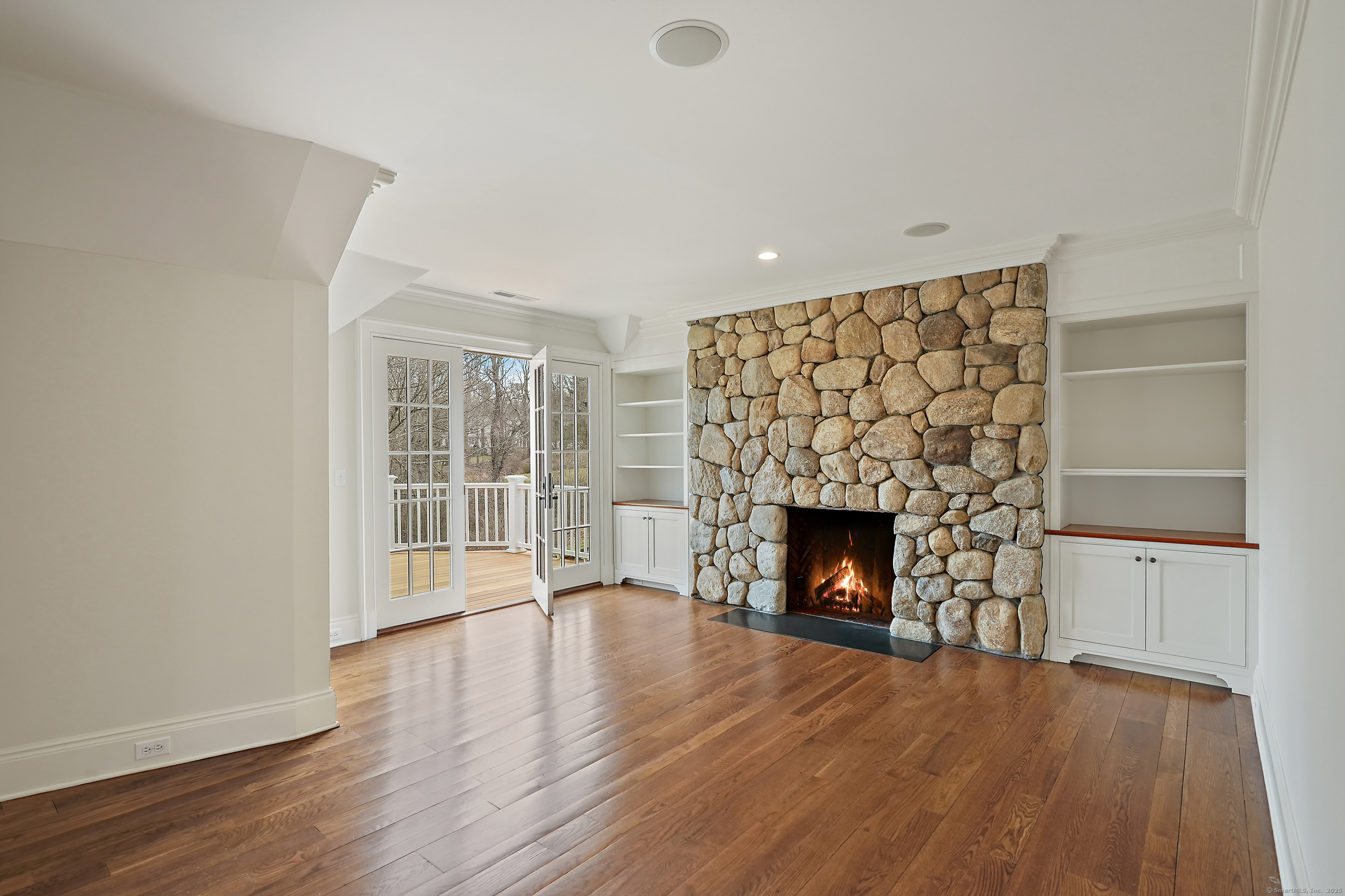 33 Middlebrook Farm Road Wilton, CT 06897 - Photo 32 of 40 an empty room with wooden floor fireplace and windows