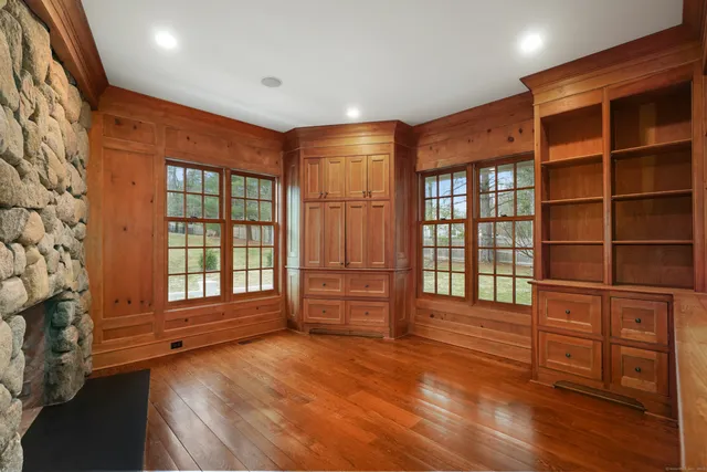 a view of an empty room with a window and wooden floor