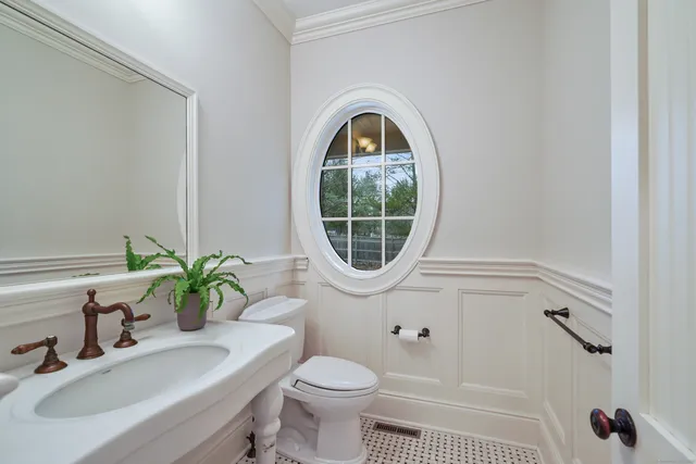 a bathroom with a sink toilet and a mirror