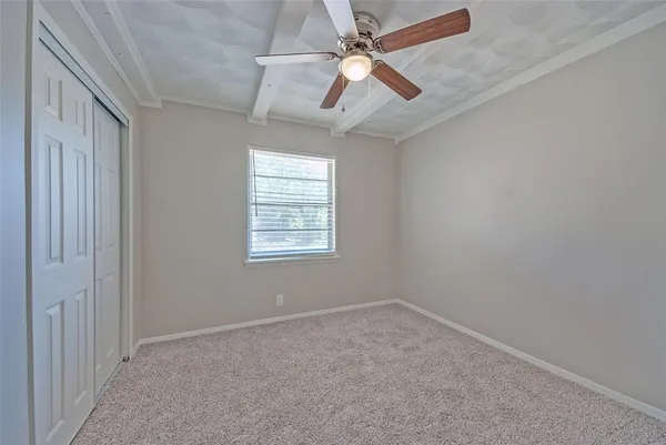 an empty room with a window and a fan