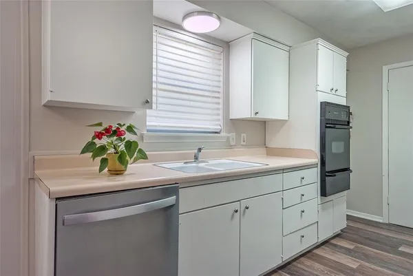 a kitchen with white cabinets and sink