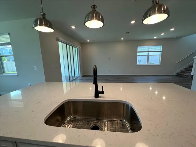 a large kitchen with stainless steel appliances granite countertop a lot of counter space and wooden floors