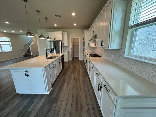 a kitchen with cabinets and wooden floor