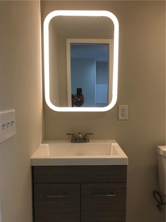1119 Spur Street, Unit A Austin, TX 78721 - Photo 7 of 10 A well-appointed bath features a sleek vanity and an illuminated mirror.
