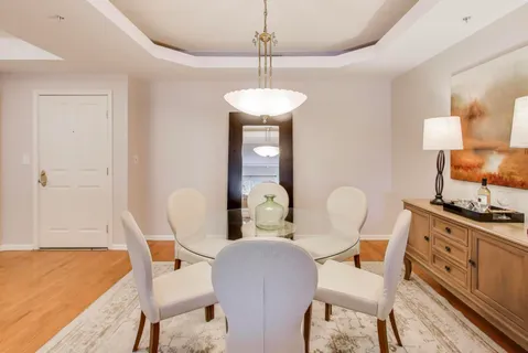 a dining room with furniture a chandelier and wooden floor