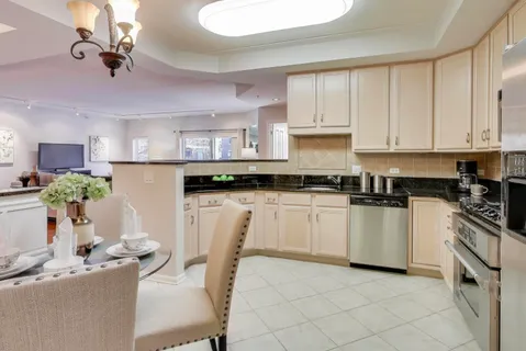 a kitchen with a white cabinets and chairs