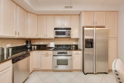 a kitchen with white cabinets and stainless steel appliances