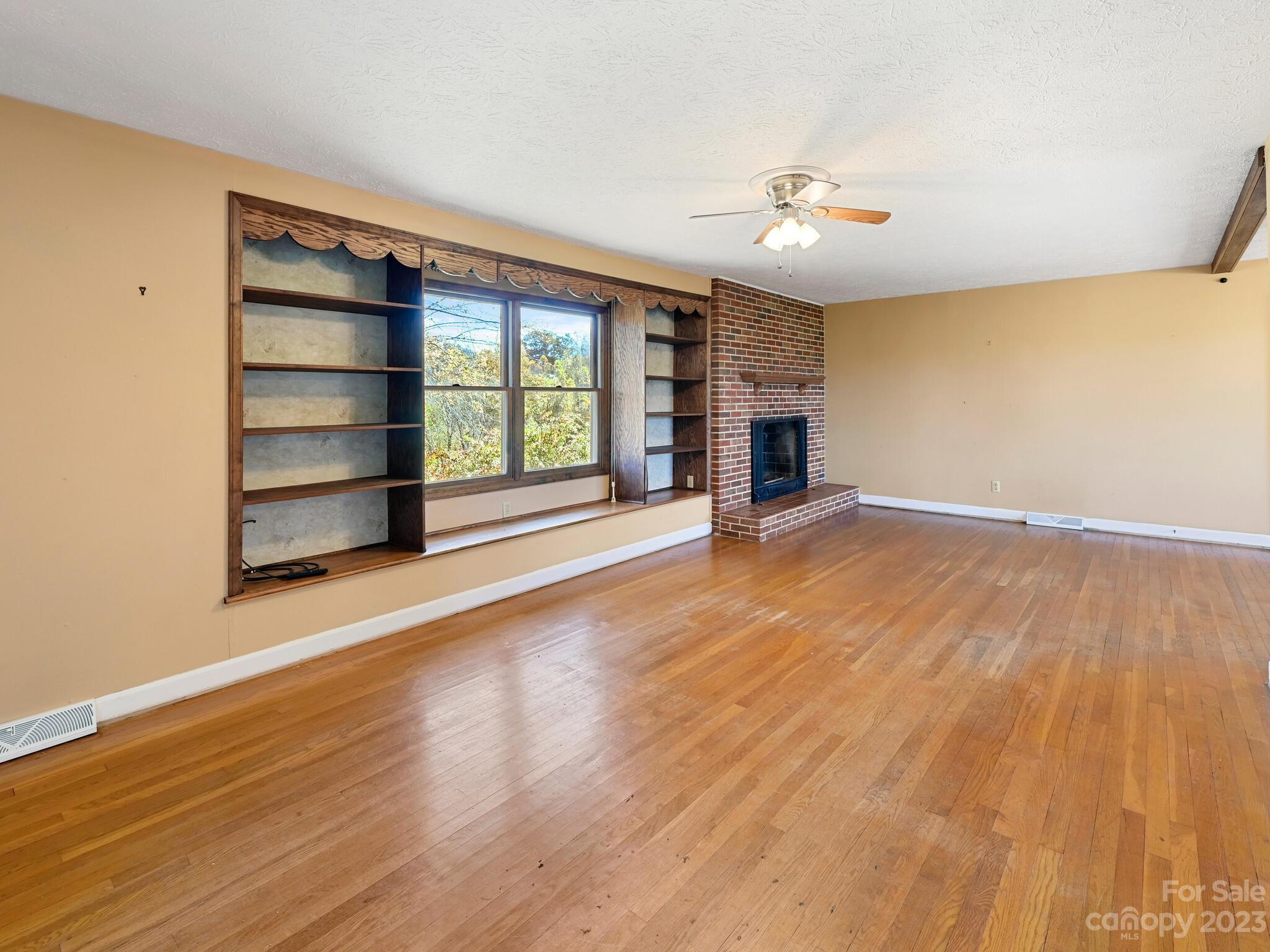 146 Old Road Marshall, NC 28753 - Photo 11 of 31 wooden floor in an empty room with a fireplace