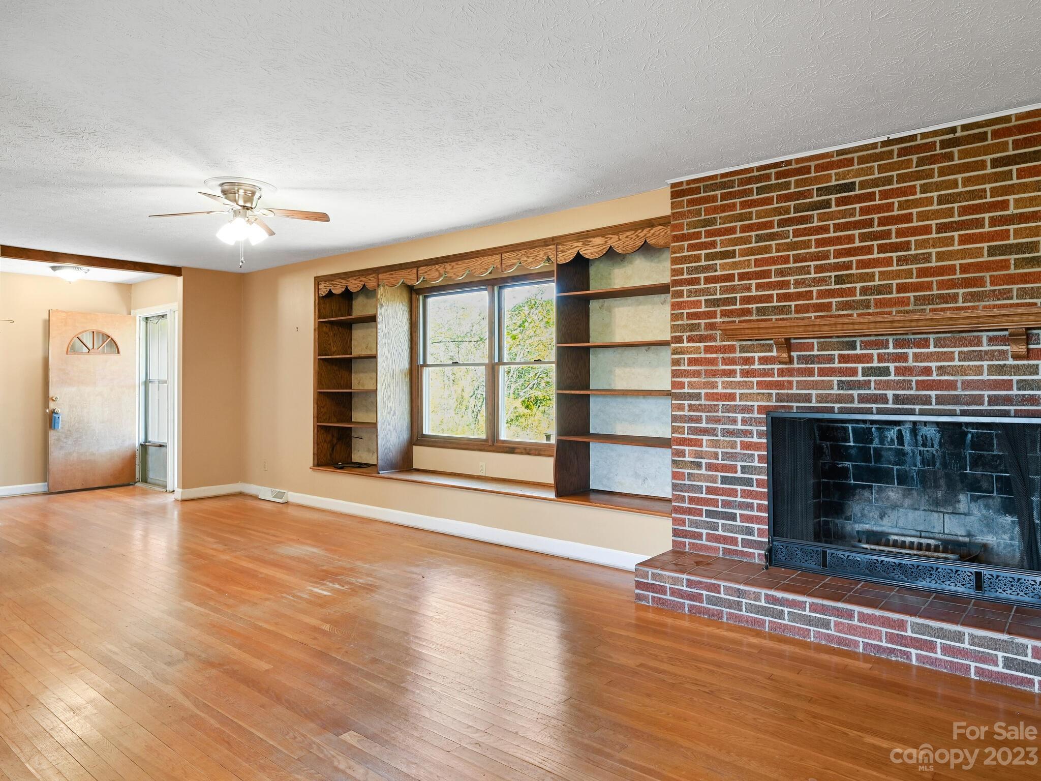 146 Old Road Marshall, NC 28753 - Photo 10 of 31 a view of an empty room with wooden floor fireplace and a window
