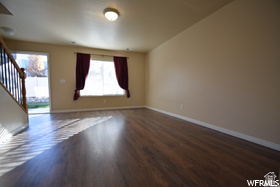 411 West 2000 South, Unit 7 Perry, UT 84302 - Photo 4 of 11 Spacious open-concept living area featuring gleaming wood-finish flooring, recessed ceiling lighting, and abundant natural light from large windows dressed in burgundy curtains