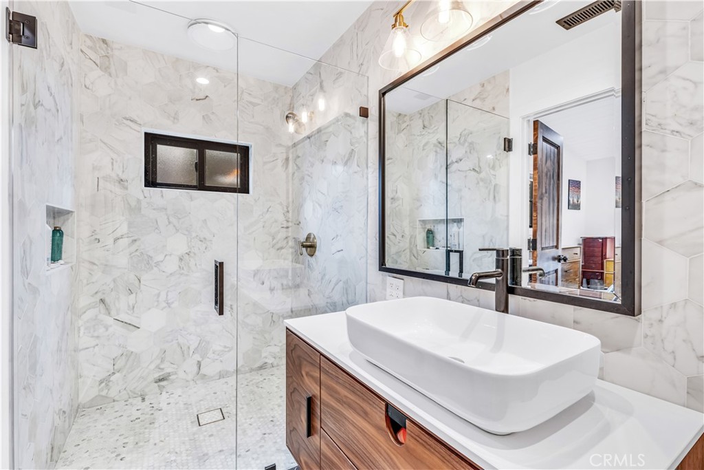 126 Avenida San Dimas San Clemente, CA 92672 - Photo 20 of 34 a bathroom with a sink a large mirror and a shower