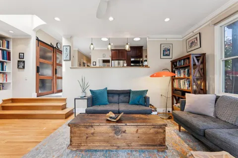 a living room with furniture and a book shelf