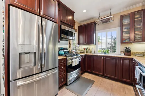 a living room with furniture kitchen view and a large window